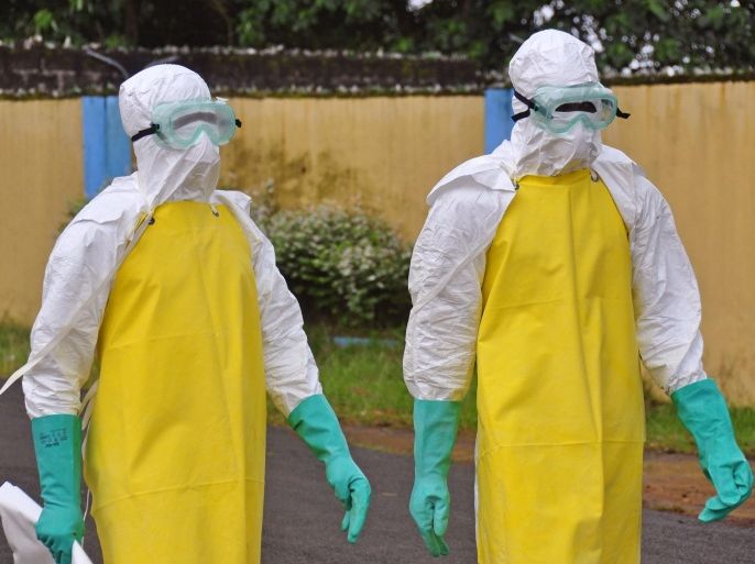 Health workers wearing protective gear go to remove the body of a person who is believed to have died after contracting the Ebola virus in the city of Monrovia, Liberia, Saturday, Aug. 16, 2014. New figures released by the World Health Organization showed that Liberia has recorded more Ebola deaths — 413 — than any of the other affected countries. (AP Photo/Abbas Dulleh)