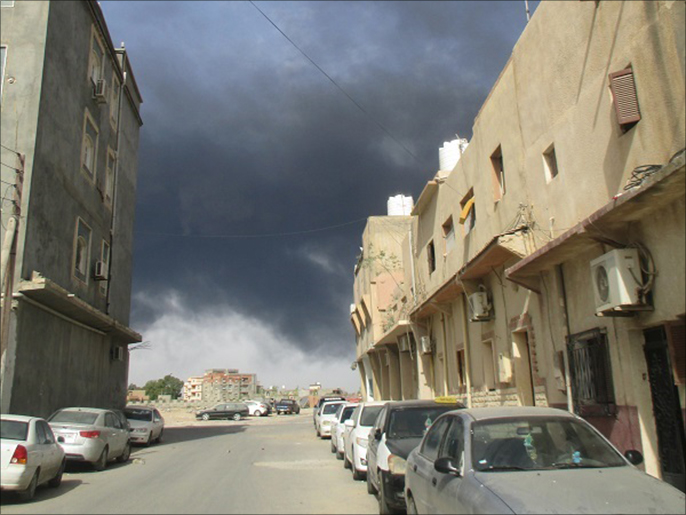 تصاعد الدخان بين الأزقة والأحياء السكنية في العاصمة طرابلس (الجزيرة)
