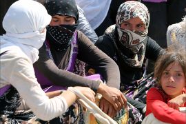 Displaced Iraqi Yazidi women gather sitting at the Bajid Kandala camp near the Tigris River, in Kurdistan's western Dohuk province,