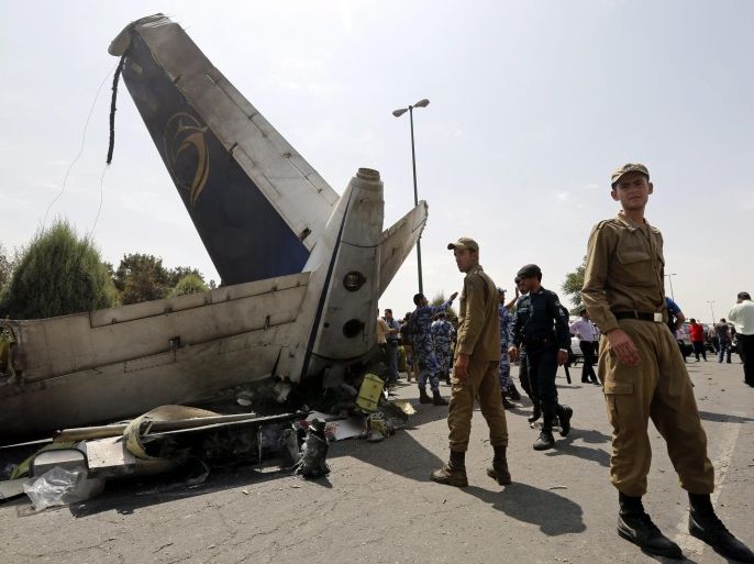 Iranian police officers and soldiers inspect the tail of a crashed airplane in Tehran, Iran, 10 August 2014. At least 40 passengers on an Iranian passenger jet were reported dead after it crashed shortly after take-off near Tehran's airport, the Irna news agency reported, citing the Iran Red Crescent Society. The plane was departing Tehran's Mehrabad airport on its way to Tabas, in the country's east.