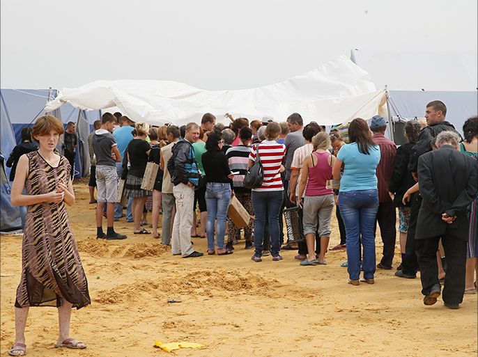 Ukrainian refugees stand queue for food supplies at a refugee camp located about 10 kilometers from the Izvarino Russia-Ukraine border checkpoint in the Rostov region, Russia, 18 August 2014. More than 100,000 residents from the separatist-held south-eastern Ukrainian regions have fled to Russia from Ukraine since June 2014 amid of armed fighting between Ukrainian troops and separatists. More than 55,000 of them are now accommodated on the territory of the Rostov region. EPA/YURI KOCHETKOV