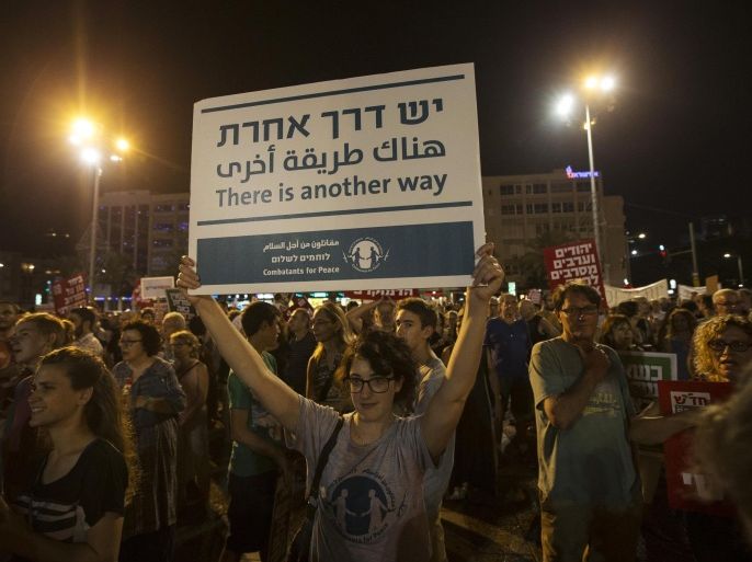 A woman holds up a placard during a peace rally in Tel Avivi's Rabin Square August 16, 2014. The protesters were demonstrating in favour of a peaceful political agreement, to end the month-long conflict in Gaza, between the Israeli and Palestinian governments. REUTERS/Baz Ratner (ISRAEL)