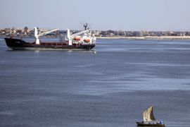 A fisherman travels on a boat near container ships in the Suez Canal, near Ismailia port city, northeast of Cairo in this May 2, 2014 file photo. Egypt is planning to build a new Suez Canal alongside the near-145 year-old historic waterway in a multi-billion dollar project aimed at expanding trade along the fastest shipping route between Europe and Asia. REUTERS/Amr Abdallah Dalsh/Files (EGYPT - Tags: BUSINESS MARITIME)
