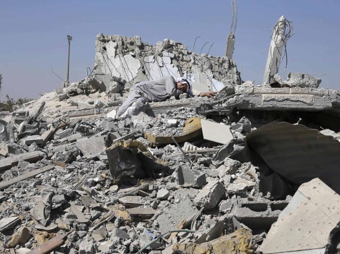 A Palestinian man lies on the ruins of his son's destroyed house in Khuzaa town, which witnesses said was heavily hit by Israeli shelling and air strikes during Israeli offensive, in the east of Khan Younis in the southern Gaza Strip August 6, 2014. With its spacious villas and palm-lined streets, the town of Khuzaa in southern Gaza gave Palestinians a rare place to spend their free time before it was bombed and shelled to rubble last month. Largely free of the local tensions and feuds found in other neighbourhoods, Khuzaa's green spaces were one of just a few destinations for daytrips in the crowded Gaza Strip, where 1.8 million people live in just 360 sq km (140 sq miles). Around 500 metres from the Israeli border, Khuzaa is now only accessible via cratered roads strewn with debris. Nearly all of its homes have been flattened and its nine mosques lie in pieces. Picture taken August 6, 2014. REUTERS/Ibraheem Abu Mustafa (GAZA - Tags: POLITICS CIVIL UNREST)
