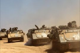 Israeli Merkava tanks and armored personnel carriers (APC) roll along the border between Israel and the Gaza Strip after they pulled out of the Gaza Strip on August 3,