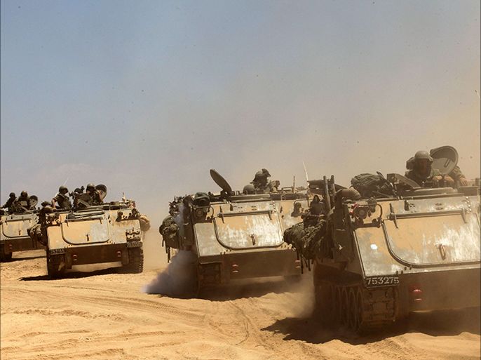 Israeli Merkava tanks and armored personnel carriers (APC) roll along the border between Israel and the Gaza Strip after they pulled out of the Gaza Strip on August 3,
