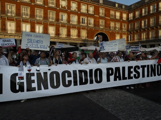 Demonstrators hold a banner that is partly seen that reads in full: "Let's Stop Palestine Genocide" as they attend a protest against the Israeli bombings in the Gaza strip, in Madrid, Thursday July 31, 2014. The U.N. humanitarian chief called Thursday for daily "humanitarian pauses" until a long-term cease-fire is reached between Israel and Hamas in order to deliver relief to hundreds of thousands in need in Gaza, rescue the injured and give civilians a reprieve from the war. (AP Photo/Daniel Ochoa de Olza)