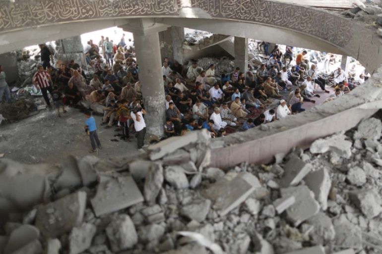 Palestinians attend Friday prayers inside a mosque which witnesses said was badly damaged by an Israel air strike during the offensive, on the second day of a five-day ceasefire in Gaza City August 15, 2014. Two successive truces since Monday, expected to last through August 19, have largely quieted the guns, after 1,945 Palestinians, most of them civilians, 64 Israeli soldiers and three civilians in Israel were killed. REUTERS/Mohammed Salem (GAZA - Tags: POLITICS CIVIL UNREST RELIGION)