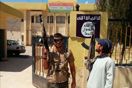 Islamic State militants stand guard after controlling a headquarters of the Kurdistan Democratic Party (KDP) in the Christian town of Bartella on the outskirts the province of Nineveh, August 7, 2014. REUTERS/Stringer (IRAQ - Tags: CIVIL UNREST POLITICS CONFLICT)