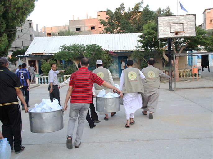 عاملين في احدى الجمعيات الخيرية يجهزون طعاما للمشردين