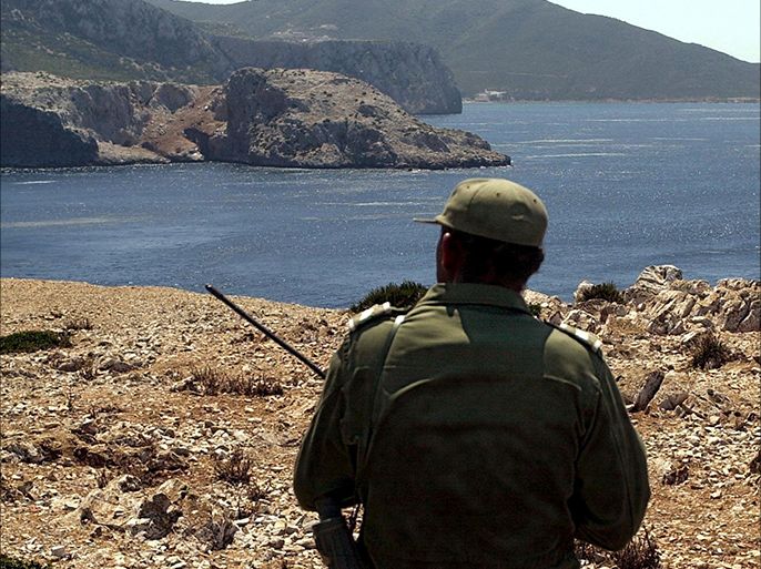 BELYOUNECH, MOROCCO : A Moroccan soldier looks at Perejil Isand, known in Morocco as Leila, on the shoreline near the village of Belyounech on Monday 15 July 2002 after 12 Moroccan soldiers landed on the rocky island last Thursday. The island, controlled by Spain since the 17th century, is a kilometer (half mile) wide and situated some six kilometers (three miles) off Ceuta, one of two Spanish enclaves along Morocco's northern coast. EPA PHOTO EFE / EMILIO MORENATTI / re fob