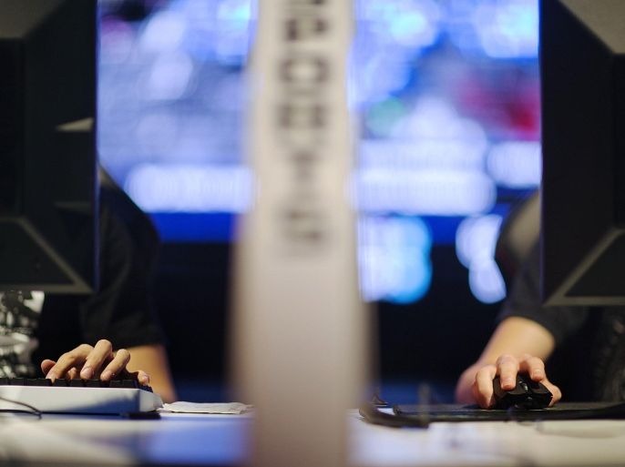 In this July 11, 2014 photo, the hand of Kim "ViOLet" Dong Hwan, left, of South Korea, types on a keyboard as the hand of Steven "Baer" Baeringer, of Coral Springs, Fla., uses a mouse while separated by a divider as they compete against each other in the Red Bull Battle Grounds "StarCraft II" video game tournament in Atlanta. Hwan is one of two competitors from South Korea who were granted professional athlete visas by the U.S. and now live and train together in Atlanta. Professional gamers and amateurs from the U.S., Canada, China, South Korea and Australia competed in the three day tournament of the science-fiction strategy video game "StarCraft II." The contestants wear special noise-canceling headphones while spectators cheer in a live arena as announcers provide the play-by-play. Choi "Bomber" Ji Sung, of South Korea, won the the 128 player bracket and the $8,000 prize purse advancing to the Battle Grounds Grand Final which takes place September 20th–21st in Washington. (AP Photo/David Goldman)