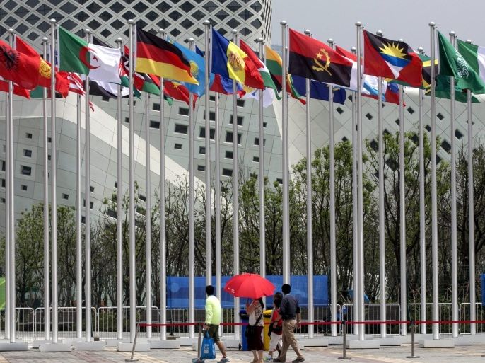 Visitors look up at the national flags of countries competing in the Nanjing 2014 Youth Olympic Games at the Youth Olympic Village in Nanjing, China, 15 August 2014. The Youth Olympic Games 2014 will hold opening ceremonies on 16 August, as close to 3,800 athletes from all over the world are set to compete in 28 sports events.