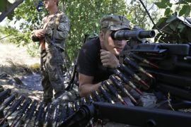 Pro-Russian rebels hold their positions on the frontline near the village of Krasnodon, eastern Ukraine, Friday, Aug. 15, 2014. Russia let Ukrainian officials inspect an aid convoy while it was still on Russian soil Friday and agreed that the Red Cross can distribute the goods in Ukraine's rebel-held city of Luhansk. (AP Photo/Sergei Grits)