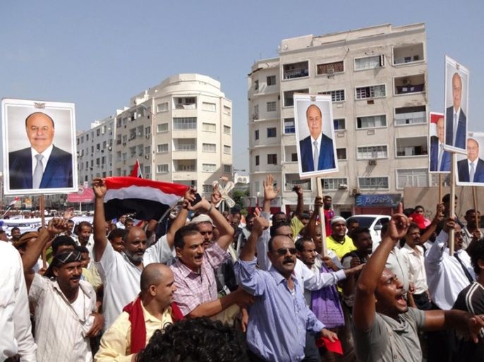 Yemeni pro-government protesters hold portraits of President Abdrabuh Mansur Hadi during a demonstration on August 28, 2014 in the southern port city of Aden. Yemeni police shot dead a protester in Aden during a demonstration by supporters of secession for the formerly independent south that came in response to the rally by government loyalists. AFP PHOTO / STR