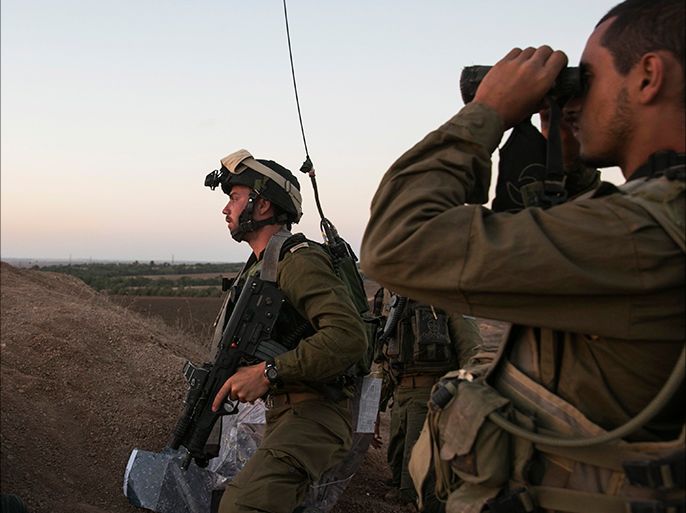 An Israeli soldier looks through binoculars at an observation post overlooking the Gaza strip near the Israeli-Gaza border August 20, 2014. An Israeli air strike in Gaza killed the wife and infant son of Hamas's military leader, Mohammed Deif, the group said, calling it an attempt to assassinate him after a ceasefire collapsed. Palestinians launched more than 100 rockets, mainly at southern Israel, with some intercepted by the Iron Dome anti-missile system, the military said. No casualties were reported on the Israeli side. REUTERS/Baz Ratner (ISRAEL - Tags: POLITICS MILITARY CONFLICT)