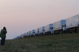 A man takes a picture of a Russian convoy of trucks carrying humanitarian aid for Ukraine that has stopped along a road near the city of Yelets August 12, 2014. The convoy carrying tonnes of humanitarian aid left on Tuesday for eastern Ukraine, where government forces are closing in on pro-Russian rebels, but Kiev said it would not allow the vehicles to cross onto its territory. Ukrainian presidential aide Valery Chaly told journalists the cargo will be reloaded onto other transport vehicles at the border by the Red Cross. Russia said it would transfer the convoy to the aegis of the International Committee of the Red Cross, but made no reference to the demand the goods be reloaded. The European Union said the aid would have to be verified. REUTERS/Maxim Shemetov (RUSSIA - Tags: POLITICS CIVIL UNREST CONFLICT)