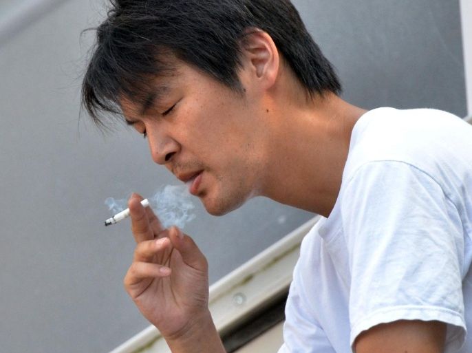 A man smokes a cigarette in Tokyo on July 31, 2014. Japan's smoking rate has dropped below 20 percent for the first time, according to a new survey, as a recent rise in cigarette prices helped to further discourage the habit. AFP PHOTO / Yoshikazu TSUNO