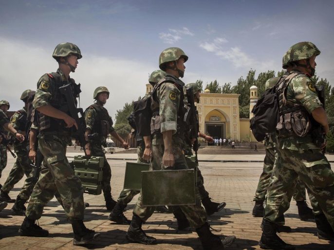KASHGAR, CHINA - JULY 31: Chinese soldiers march in front of the Id Kah Mosque, China's largest, on July 31, 2014 in Kashgar, China. China has increased security in many parts of the restive Xinjiang province following some of the worst violence in months in the Uyghur dominated area.
