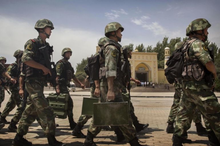 KASHGAR, CHINA - JULY 31: Chinese soldiers march in front of the Id Kah Mosque, China's largest, on July 31, 2014 in Kashgar, China. China has increased security in many parts of the restive Xinjiang province following some of the worst violence in months in the Uyghur dominated area.