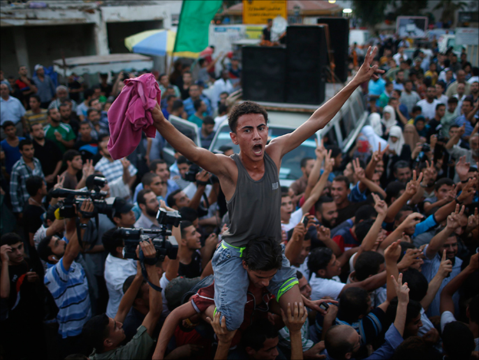 رغم الآلام خرج آلاف الفلسطينيين بغزة فرحا ببنود وقف إطلاق النار مع إسرائيل (رويترز)