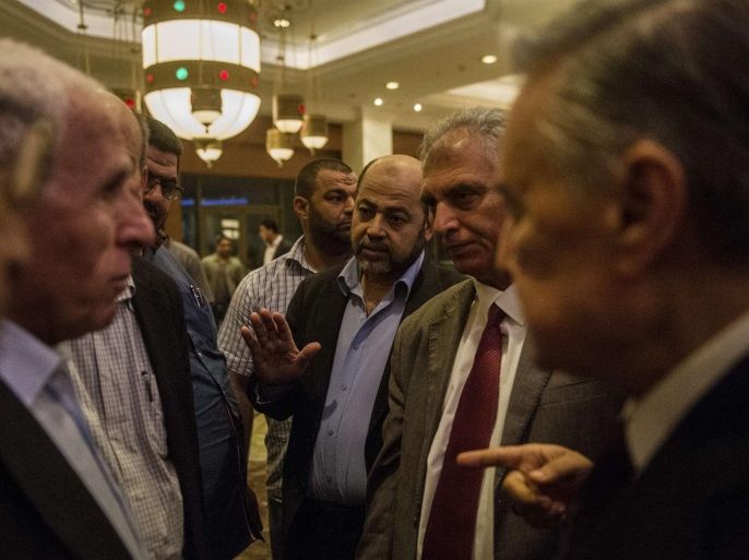Hamas deputy leader Musa Abu Marzuk (C) and others members of the Palestinian delegation talk to the head of the Palestinian delegation Azzam al-Ahmed (L) upon their arrival at the hotel after a meeting with Egyptians seniors intelligence in Cairo August 11, 2014. A fresh 72-hour ceasefire between Israel and Hamas came into effect in Gaza Monday, paving the way for talks in Egypt aimed at a durable end to a month-long conflict that has wreaked devastating bloodshed. AFP PHOTO / KHALED DESOUKI
