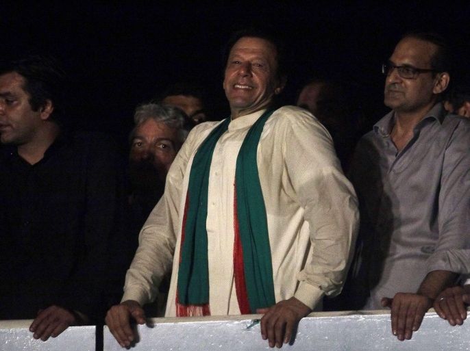 Imran Khan (C), cricketer-turned-opposition politician and chairman of the Pakistan Tehreek-e-Insaf (PTI) political party, smiles to his supporters after his speech during the fourth day of the Freedom March in Islamabad August 17, 2014. Tens of thousands of anti-government protesters flooded the centre of Pakistan's capital on Saturday, vowing to stay in the streets until Prime Minister Nawaz Sharif resigns. REUTERS/Faisal Mahmood (PAKISTAN - Tags: POLITICS CIVIL UNREST)