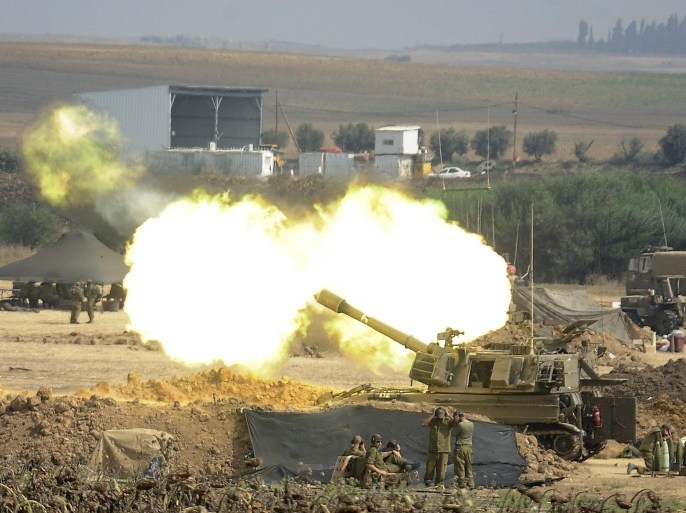 An Israeli canon fires a 155mm shell towards targets in the Gaza Strip from their position along the border between Israel and the Hamas-controlled Gaza Strip on July 29, 2014. Bloodshed in war-torn Gaza surged on with dozens more Palestinians killed as the conflict raged into a fourth week and Iran accused Israel of genocide in the tiny enclave. AFP PHOTO/ DAVID BUIMOVITCH