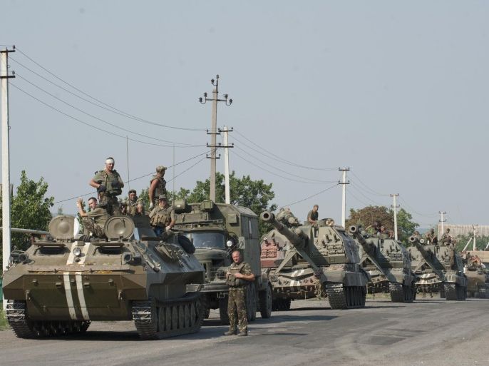In this photo taken on Thursday, Aug. 14, 2014, an Ukrainian army column of military vehicles prepares to roll to a frontline near Illovaisk, Donetsk region, eastern Ukraine. Ukrainian forces have stepped up efforts to dislodge the separatists from their last strongholds in Donetsk and Luhansk and there was more heavy shelling overnight. (AP Photo/Evgeniy Maloletka)