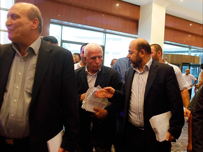 Senior Hamas official and delegation leader Moussa Abu Marzouk (R) talks with Fatah official and delegation leader Azzam Ahmed (C) as they arrive at a hotel after negotiations in Cairo August 13, 2014. The threat of renewed war in Gaza loomed on Wednesday as the clock ticked toward the end of a three-day ceasefire with no sign of a breakthrough in indirect talks in Cairo between Israel and the Palestinians. Seen at left is Maher al-Taher from the Popular Front for the Liberation of Palestine. REUTERS/Asmaa Waguih (EGYPT - Tags: POLITICS CONFLICT CIVIL UNREST)