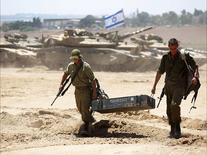 epa04342765 Israeli soldiers carry their gears as they move to a staging area at an unspecified location near the Israeli border with the Gaza Strip, 06 August 2014. The Palestinians are considering extending the 72-hour ceasefire in the