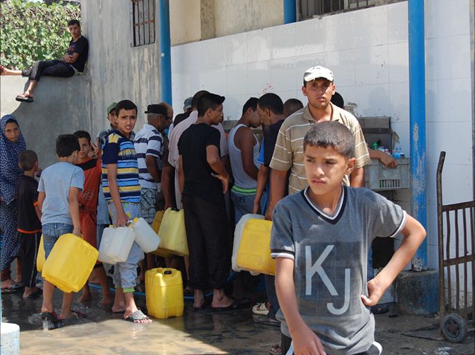 توافد المشردين وتزاحمهم على احدى محطات الدفاع المدني للتزود بالماء في مدينة خانيونس