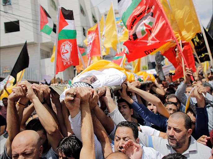 Mourners carry the body of Palestinian Nader Driss, whom medics said died of a gunshot wound by Israeli troops during clashes at a protest against the Israeli offensive in Gaza, during his funeral in the West Bank City of Hebron August 9, 2014. Violence picked up in the occupied West Bank, the Palestinian territory where President Mahmoud Abbas's Fatah movement holds sway, where, Driss, a Palestinian man, 43, died of a gunshot wound to the chest from a confrontation with Israeli soldiers in the city of Hebron, medical officials said. Israeli troops shot and killed another Palestinian man, 20, on Friday at a protest near a Jewish settlement outside Ramallah, Israeli military officials said. Israel launched more than 20 aerial attacks in Gaza on Saturday, killing five Palestinians, and militants fired rockets at Israel as the conflict entered a second month, defying international efforts to negotiate an agreement for an extended ceasefire. REUTERS/Ammar Awad (WEST BANK - Tags: POLITICS CIVIL UNREST CONFLICT) TEMPLATE OUT