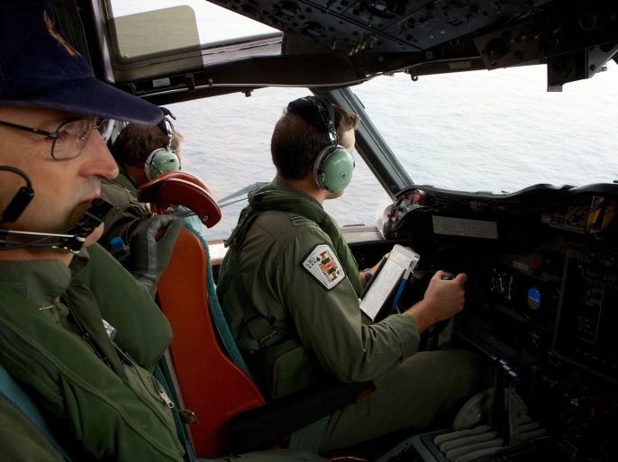 Co-Pilot, Flying Officer Marc Smith (R) and crewmen aboard a Royal Australian Air Force (RAAF) AP-3C Orion aircraft, search for the missing Malaysian Airlines Flight MH370 over the southern Indian Ocean in this March 24, 2014 file photo. Malaysia on August 28, 2014 said it would share with Australia the cost of the latest effort to uncover signs of the missing flight MH370, in the hope of unlocking modern aviation's greatest mystery. Months of searches have failed to turn up any trace of the missing aircraft, which disappeared on March 8. REUTERS/Richard Wainwright/Pool/Files (AUSTRALIA - Tags: MILITARY TRANSPORT DISASTER POLITICS)