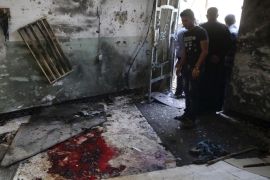 Worshipers look at blood stains inside the Imam Ali mosque after a suicide bomb attack in New Baghdad, Iraq, Monday, Aug. 25, 2014. Iraqi officials say a wave of attacks targeting commercial areas in and outside Baghdad has killed and wounding scores of people. They say the deadliest of Monday's bombings was carried out by a suicide bomber who blew up himself among Shiite worshippers who were leaving Imam Ali mosque after noon prayers in the capital's eastern New Baghdad area, killing over a dozen people and wounding many others. (AP Photo/ Khalid Mohammed)