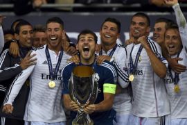 Real Madrid's captain Iker Casillas (C) prepares to raise the trophy beside team mates after winning the UEFA Super Cup final against Sevilla at Cardiff City stadium, Wales, August 12, 2014. REUTERS/Dylan Martinez (BRITAIN - Tags: SPORT SOCCER)