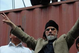 - Islamabad, -, PAKISTAN : Canada-based preacher Tahir-ul-Qadri gestures as he arrives to address supporters during an anti government march in Islamabad on August 16, 2014. Populist cleric Tahir-ul-Qadri led thousands of his followers alongside politician Imran Khan in his own march on the capital to force the Sharif government to step down. Both Khan and Qadri plan to rally in Islamabad until their demands for Sharif's resignation and for electoral reforms are met. AFP PHOTO/Asif HASSAN