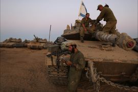 epa04349744 Israeli soldiers next to a Merkava tanks near the Israeli border with the Gaza Strip, 11 August 2014. Israeli negotiators arrived in Cairo on 11August 2014 for indirect talks mediated by Egypt on a long-term truce for the Gaza Strip, as a temporary three-day ceasefire was taking hold. EPA/ABIR SULTAN