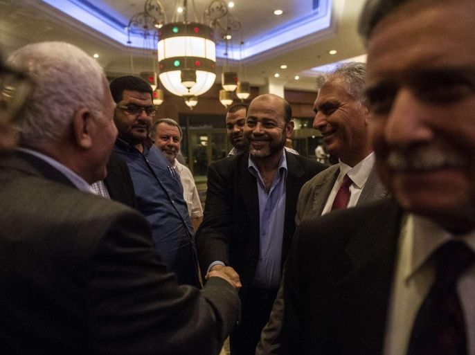 Hamas deputy leader Musa Abu Marzuk (C) shakes hands with head of the Palestinian delegation Azzam al-Ahmed (L) upon their arrival at the hotel after a meeting with Egyptians seniors intelligence in Cairo August 11, 2014. A fresh 72-hour ceasefire between Israel and Hamas came into effect in Gaza Monday, paving the way for talks in Egypt aimed at a durable end to a month-long conflict that has wreaked devastating bloodshed. AFP PHOTO / KHALED DESOUKI
