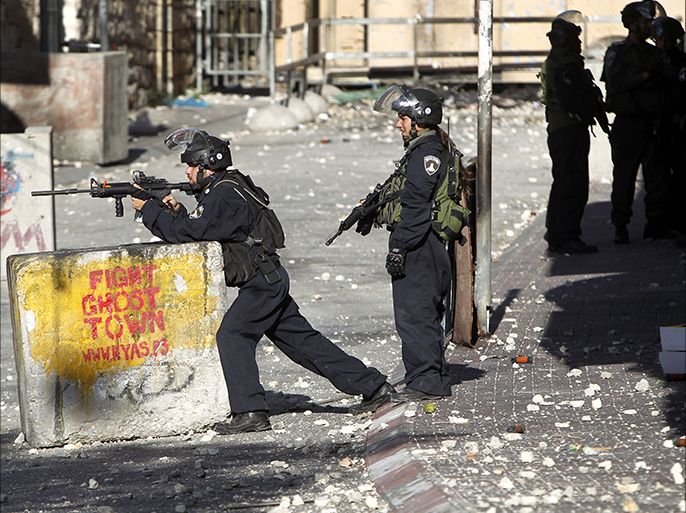 epa04347365 Israeli Border Police, including a young woman (2 L) take positions during clashes with Palestinian stone throwers in the West Bank city of Hebron, 09 August 2014. Scattered clashes continue in the West Bank in solidarity with the Palestinians conflict with Israel in the Gaza Strip. EPA/ABED AL HASHLAMOUN