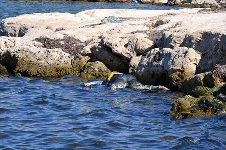 A picture taken on August 29, 2014 shows the body floating on the water after a boat carrying illegal migrants from Libya sank off the shores of the coastal town of Ben Guerdane, in southeast Tunisia.Tunisia rescuers recovered the bodies of at least 14 people drifting at sea near Libya's maritime borders, in an area that has seen many boatloads of illegal migrants capsize. AFP PHOTO / F NASRI