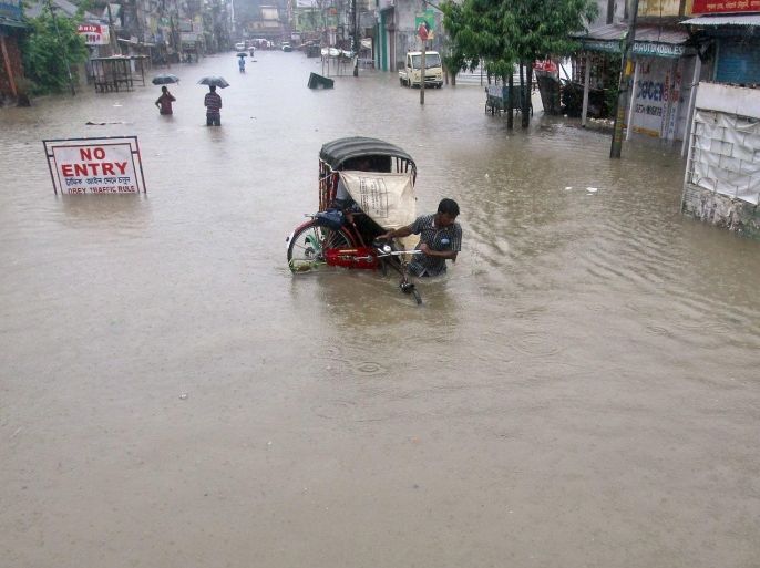 A man pulls a cycle rickshaw through a flooded street during a heavy monsoon rain shower in Agartala, capital of India's northeastern state of Tripura August 14, 2014. India has forecast June-September monsoon rainfall would be 87 percent of the long-term average but sees no evidence of drought, a relief to government officials worried by the risk of a surge in food prices. REUTERS/Jayanta Dey (INDIA - Tags: ENVIRONMENT)
