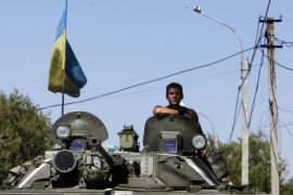 A Ukrainian serviceman sits atop an armoured vehicle as he guards a checkpoint outside Donetsk, August 15, 2014. The European Union said on Friday it would consider any unilateral military actions by Russia in Ukraine as "a blatant violation of international law". REUTERS/Valentyn Ogirenko (UKRAINE - Tags: MILITARY POLITICS CIVIL UNREST CONFLICT)