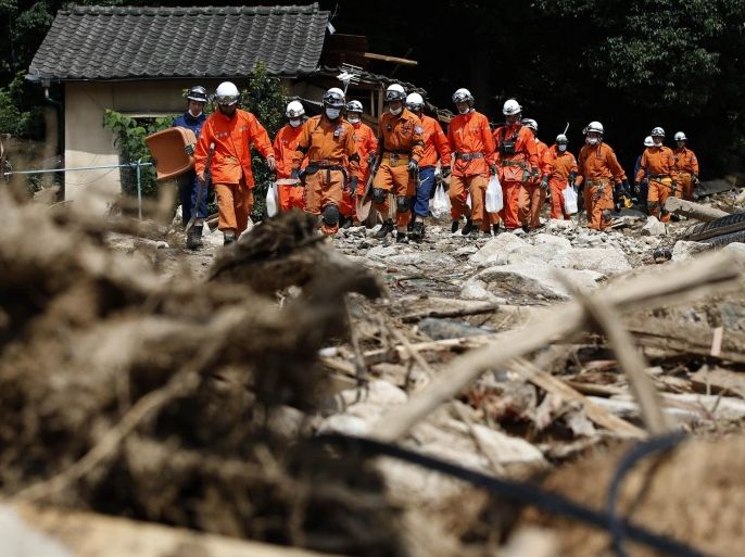 Firefighters walk as they search for survivors at a site where a landslide swept through a residential area at Asaminami ward in Hiroshima, western Japan, August 23, 2014. Heavy rain delayed a search on Friday for more than 50 people believed buried under a deadly landslide on the edge of the Japanese city of Hiroshima, as opposition politicians rounded on Prime Minister Shinzo Abe for his handling of the disaster. REUTERS/Toru Hanai (JAPAN - Tags: DISASTER ENVIRONMENT)