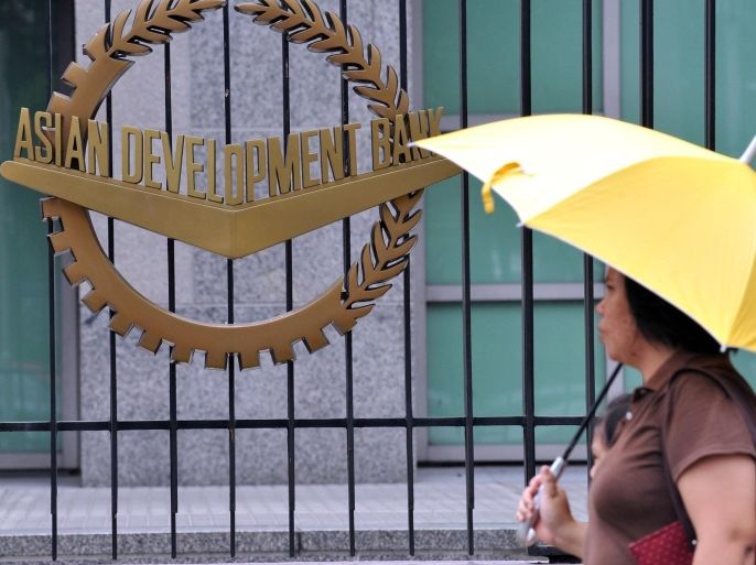 A pedestrian walks past a logo of Asian Development Bank (ADB) displayed outside its headquarters in Manila on September 2, 2010. The Philippines said it would fail to meet its UN development goal on halving poverty levels by 2015 after even more people were added to the ranks of the poor in recent years. The ADB has announced a 400-million-dollar loan to expand a conditional cash transfer programme for poor families.