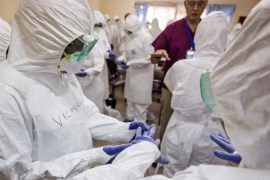 A World Health Organization, WHO, worker, right rear, trains nurses to use Ebola protective gear in Freetown, Sierra Leone, Thursday, Sept. 18, 2014. Shoppers crowded streets and markets in Sierra Leone's capital on Thursday stocking up for a three-day shutdown that authorities will hope will slow the spread of the Ebola outbreak that is accelerating across West Africa. (AP Photo/Michael Duff)