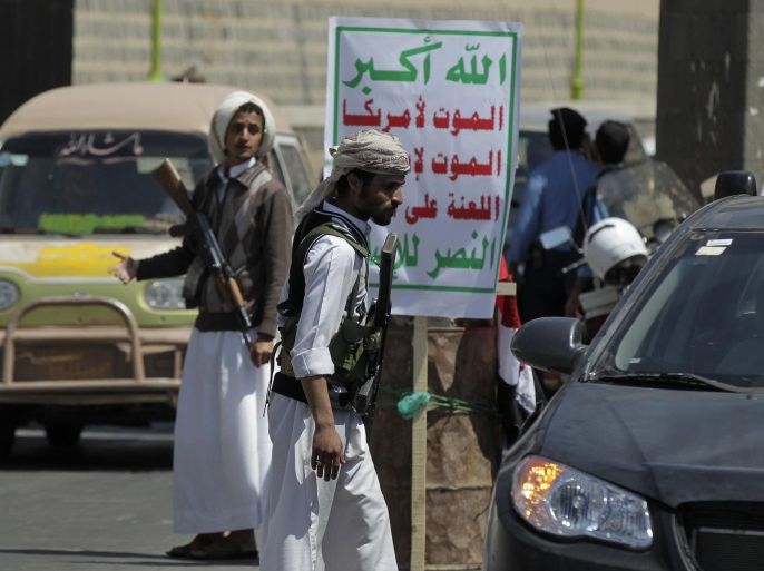 Shi'ite Houthi rebels man a checkpoint in Sanaa September 24, 2014. The leader of a Shi'ite rebel group on Tuesday hailed the takeover by his fighters of much of the Yemeni capital after four days of fighting last week as a "successful revolution" for all citizens. The banner reads "Allah is the greatest. Death to America, death to Israel, a curse on the Jews, victory to Islam". REUTERS/Khaled Abdullah (YEMEN - Tags: POLITICS CIVIL UNREST)