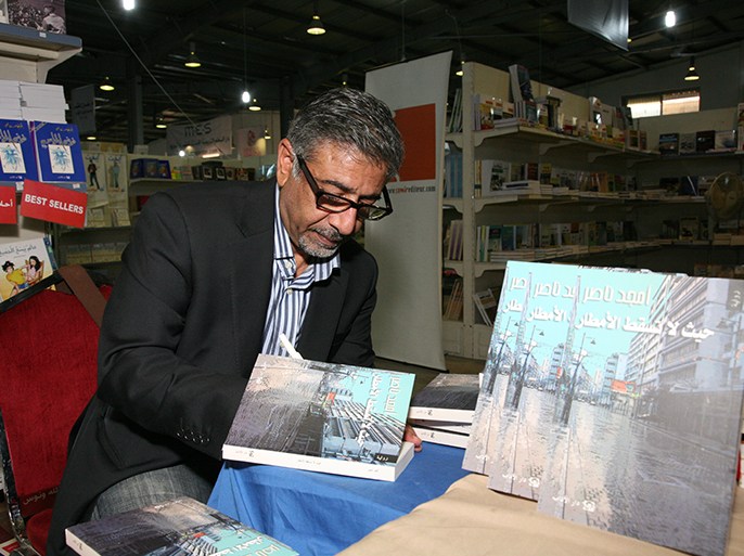 الكاتب أمجد ناصر اثناء توقيع حيث لا تسقط الامطار في عمان