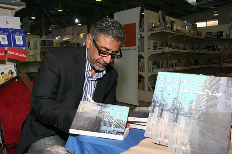 الكاتب أمجد ناصر اثناء توقيع حيث لا تسقط الامطار في عمان