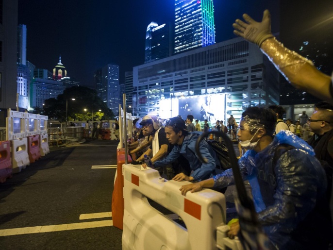 متظاهرون مطالبون بالديمقراطية يدفعون حواجز وسط مدينة هونغ كونغ (رويترز)